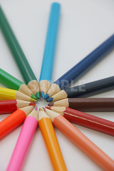 斜め上から見た放射状に並ぶ色鉛筆の写真（中央ずらし）