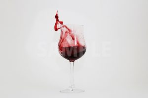 グラスから飛び出る赤ワインの写真・フォト
