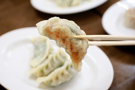 餃子を箸で持った写真・フォト素材